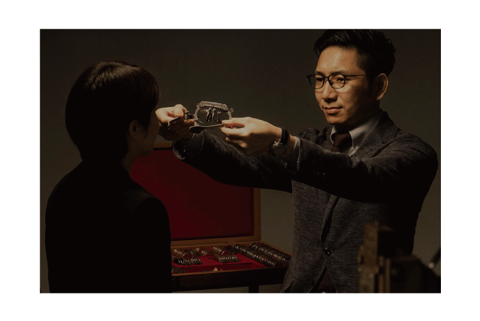 メガネを手に持った男性がほかの人にかけさせ良いとしている